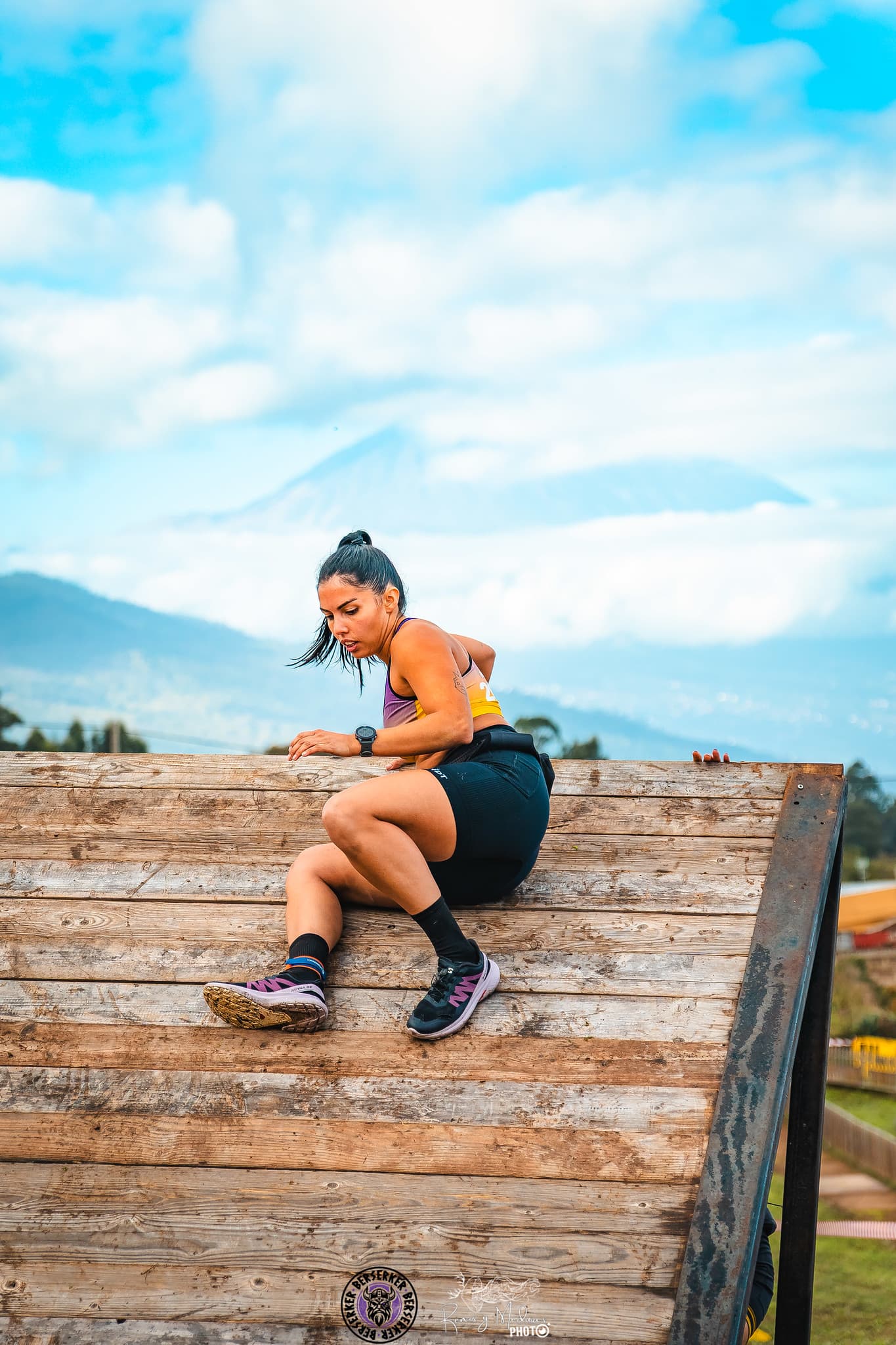 Atleta escalando muro en carrera OCR